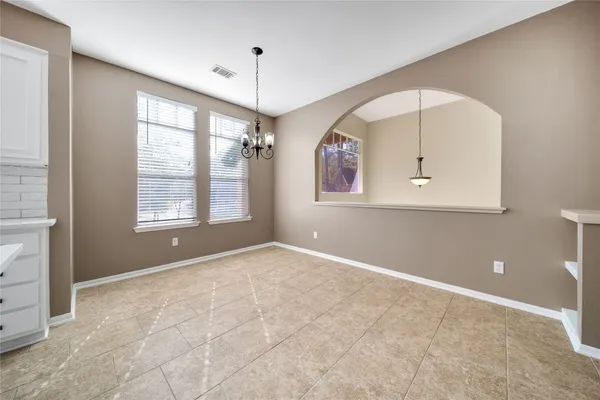 an empty room with a ceiling fan and windows