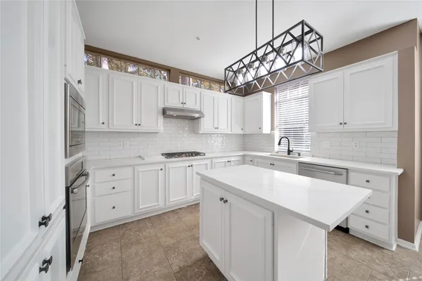 a kitchen with white cabinets and white appliances