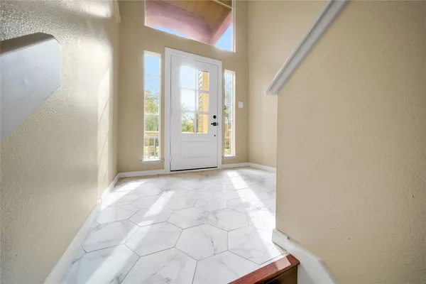a view of a hallway with wooden floor and windows