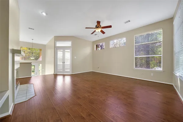a view of an empty room with window and wooden floor