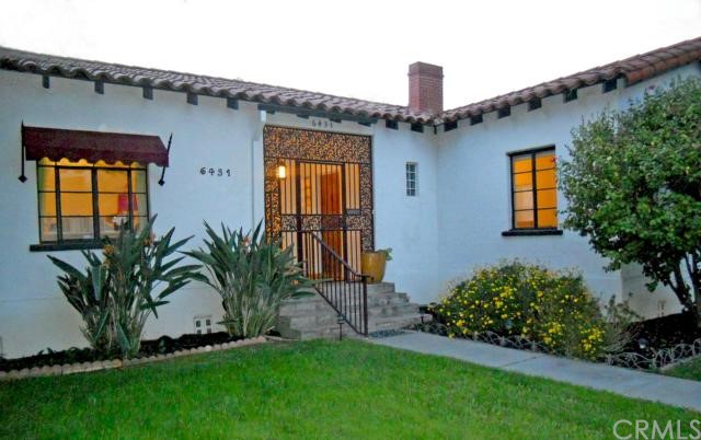 Elegant Spanish facade complete with Spanish-tile roof and awnings with wrought iron finials.