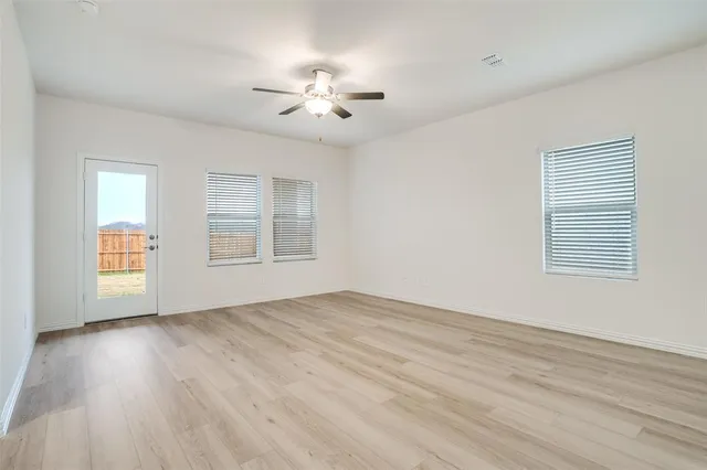 an empty room with windows & cabinet mirror