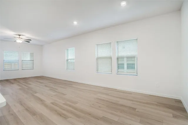 a view of an empty room and a kitchen