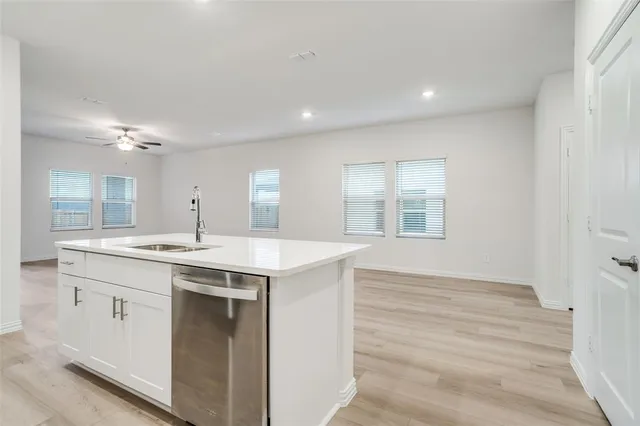 a kitchen with kitchen island a sink stainless steel appliances and cabinets