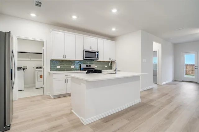 a kitchen with stainless steel appliances a refrigerator sink and microwave