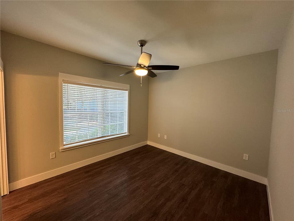 10000 Southwest 52nd Avenue, Unit 139 Gainesville, FL 32608 - Photo 14 of 16 a view of a room with wooden floor ceiling fan and windows