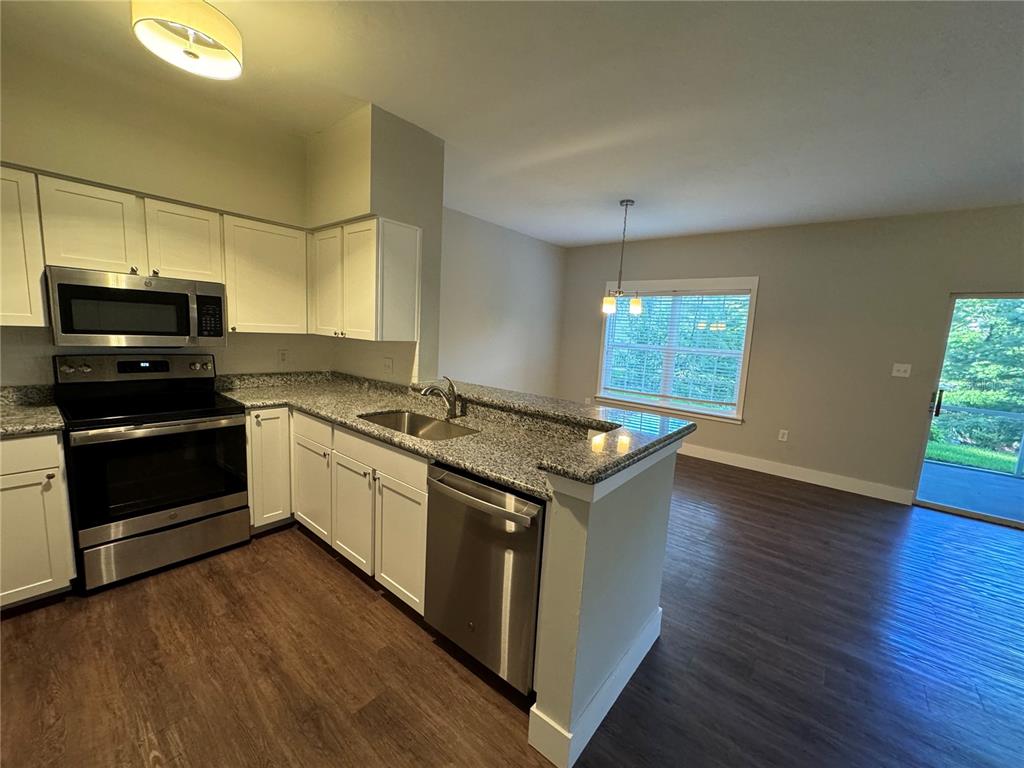 10000 Southwest 52nd Avenue, Unit 139 Gainesville, FL 32608 - Photo 3 of 16 a kitchen with a stove and a microwave