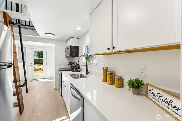 a kitchen with a sink appliances and cabinets
