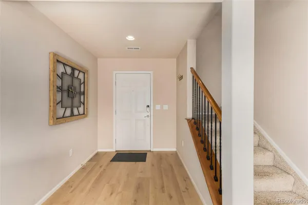 a view of a hallway with wooden floor and entryway