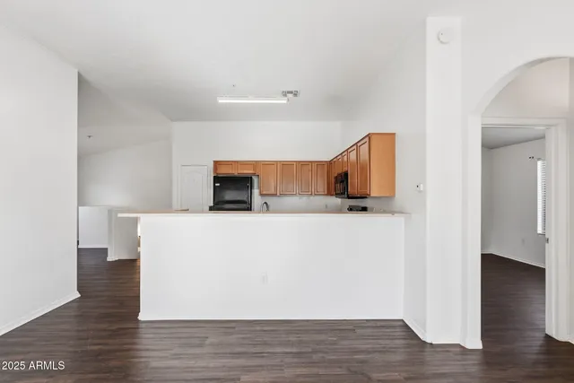 a view of a kitchen with wooden floor and a ceiling fan