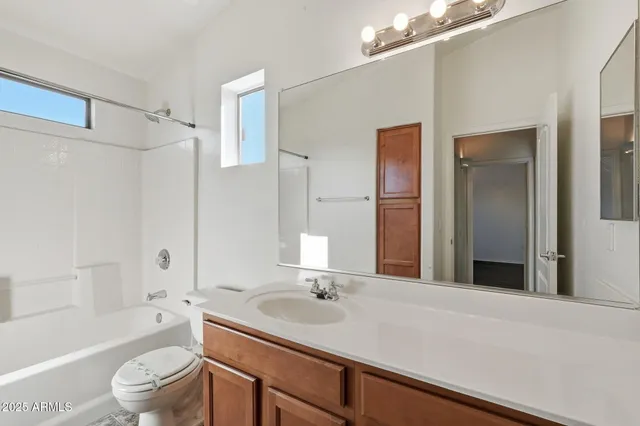 a white bath tub sitting next to a white sink and vanity