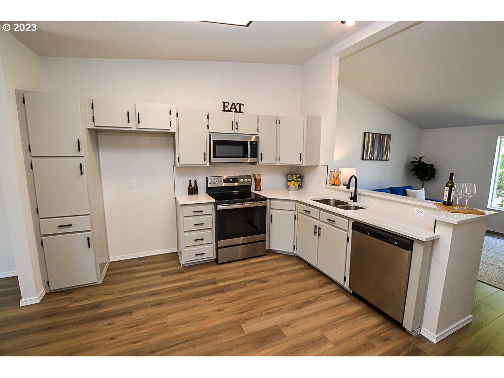 5332 Bridgewater Drive Eugene, OR 97402 - Photo 13 of 28 a kitchen with cabinets wooden floor and stainless steel appliances