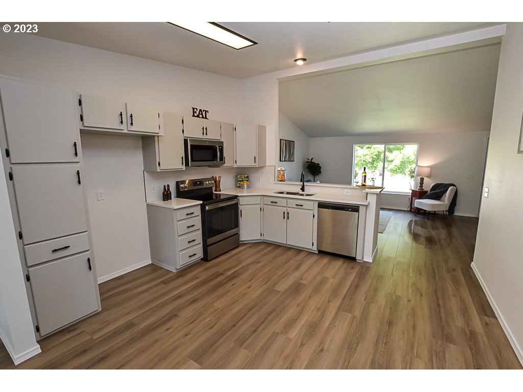 5332 Bridgewater Drive Eugene, OR 97402 - Photo 14 of 28 a kitchen with stainless steel appliances granite countertop a stove top oven a sink dishwasher and a refrigerator