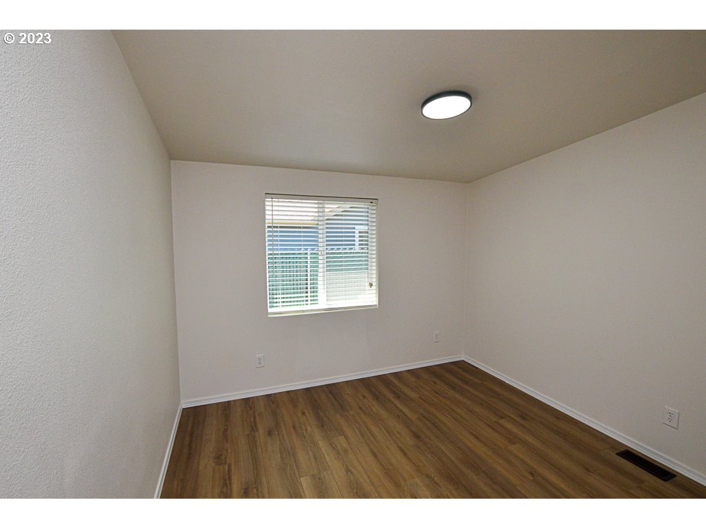 5332 Bridgewater Drive Eugene, OR 97402 - Photo 21 of 28 a view of an empty room with wooden floor and a window