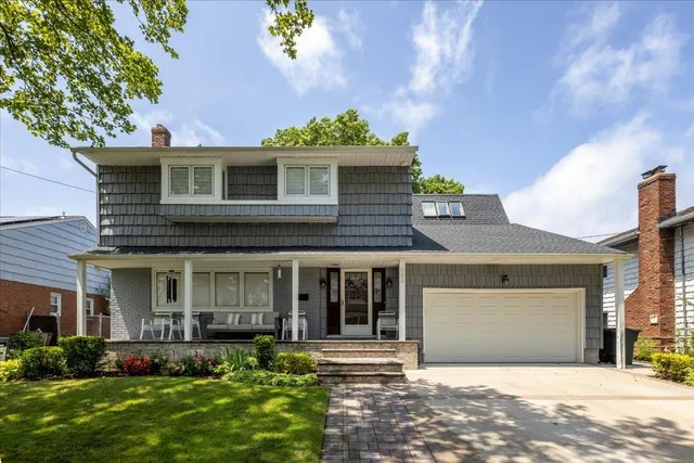 a front view of a house with a yard and potted plants