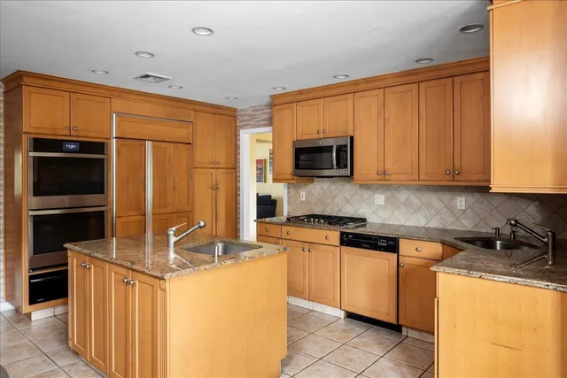 a kitchen with stainless steel appliances granite countertop a stove top oven a sink dishwasher and a microwave oven with cabinets