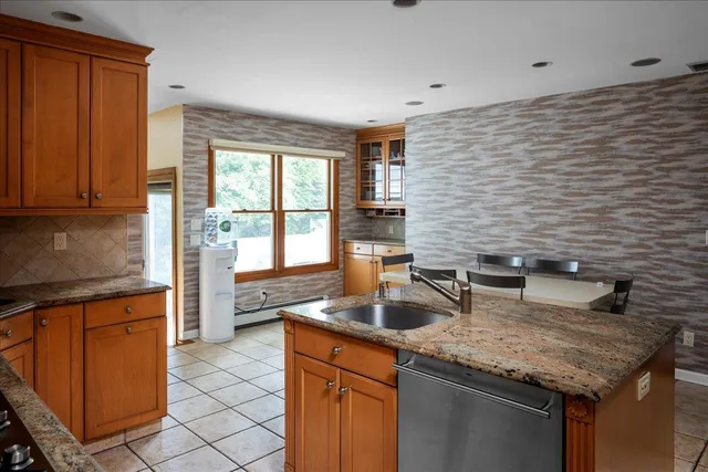 a kitchen with granite countertop a sink and a refrigerator