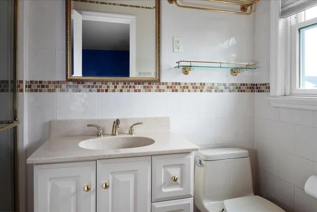 a bathroom with a toilet sink and mirror