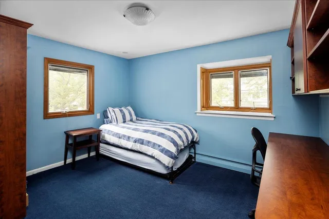 a bedroom with a bed chair and a window