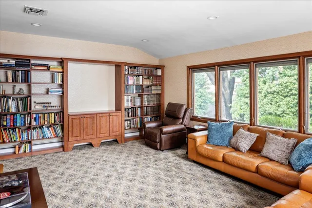 a living room with furniture a bookshelf and a large window