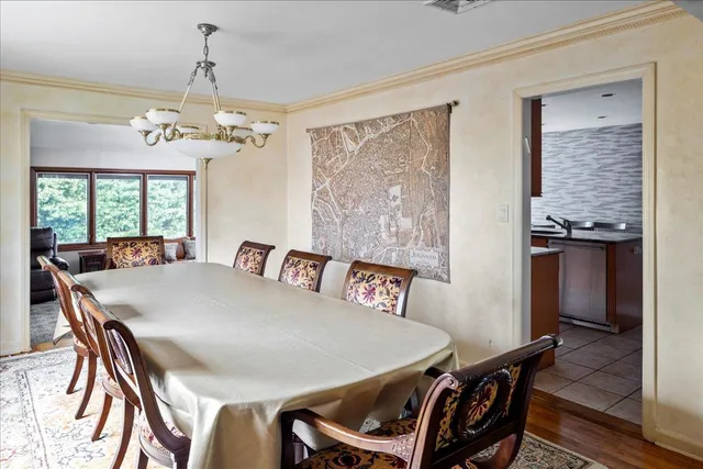 a view of a dining room with furniture a chandelier and wooden floor
