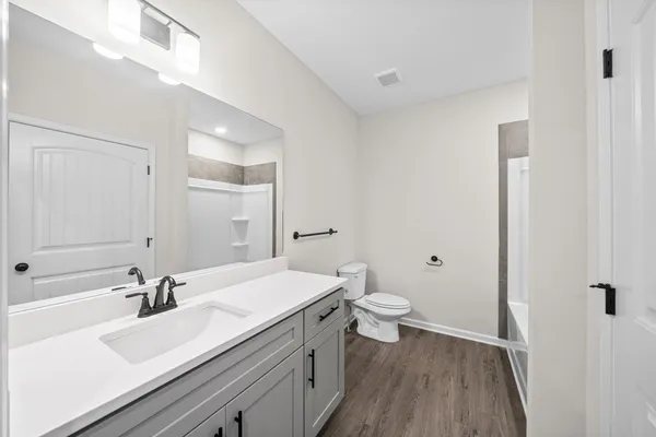 a bathroom with a sink a toilet and a large mirror