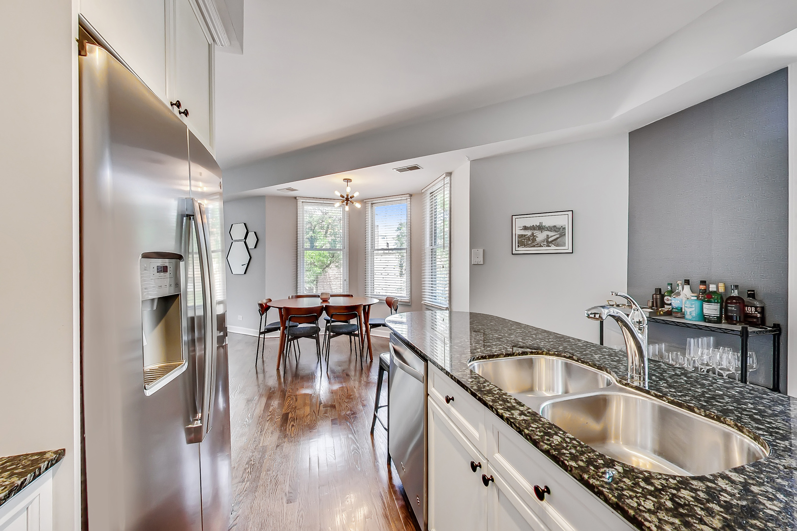 845 West Altgeld Street, Unit 2A Chicago, IL 60614 - Photo 11 of 24 a kitchen with granite countertop a sink a stove and dining table with wooden floor