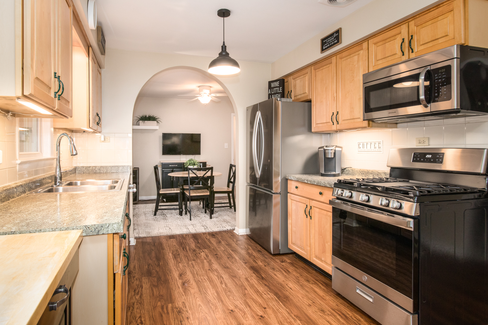 740 North Dee Road Park Ridge, IL 60068 - Photo 6 of 22 a kitchen with stainless steel appliances granite countertop a stove top oven a sink dishwasher a dining table and chairs with wooden floor