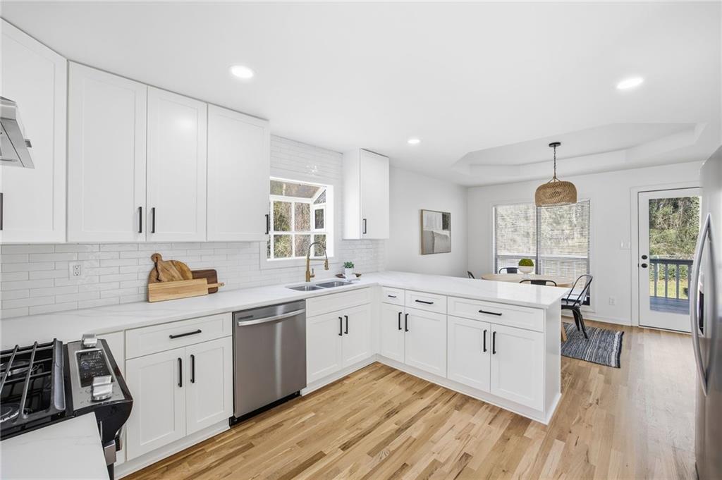 68 Winward Way Southeast Smyrna, GA 30082 - Photo 11 of 42 a large white kitchen with stainless steel appliances granite countertop a stove and a sink