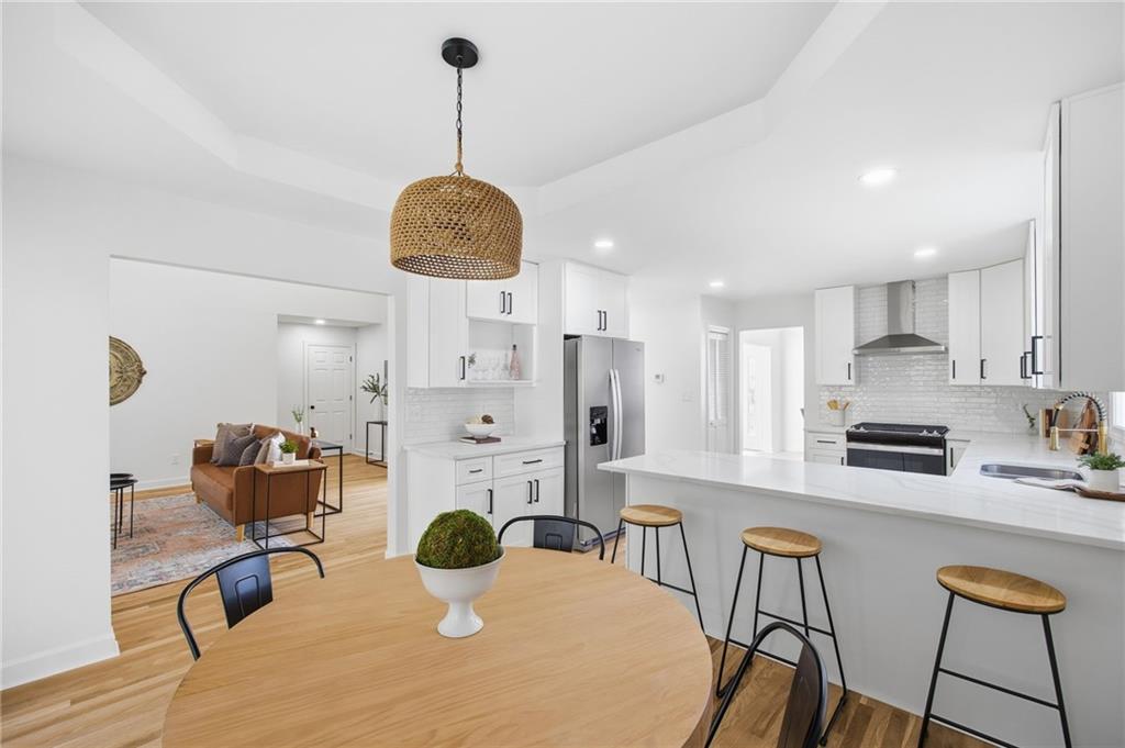 68 Winward Way Southeast Smyrna, GA 30082 - Photo 13 of 42 a kitchen with stainless steel appliances kitchen island granite countertop a dining table chairs and white cabinets