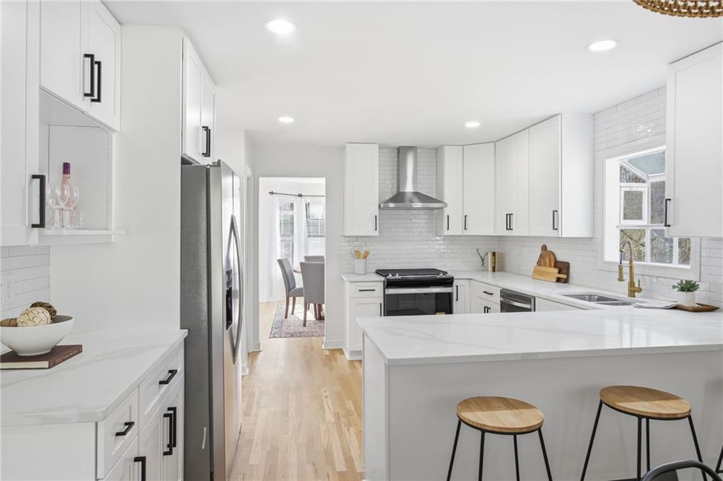68 Winward Way Southeast Smyrna, GA 30082 - Photo 10 of 42 a kitchen with stainless steel appliances granite countertop a stove a sink a refrigerator white cabinets and chairs with wooden floor