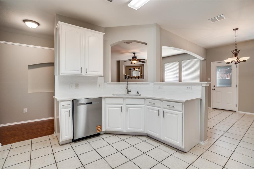 8308 Ram Ridge Road Fort Worth, TX 76137 - Photo 11 of 24 a kitchen with granite countertop white cabinets and white appliances
