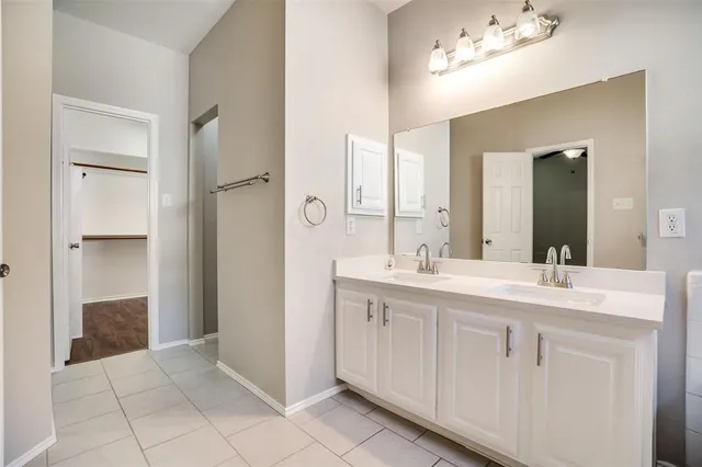 a spacious bathroom with a double vanity sink a mirror and shower