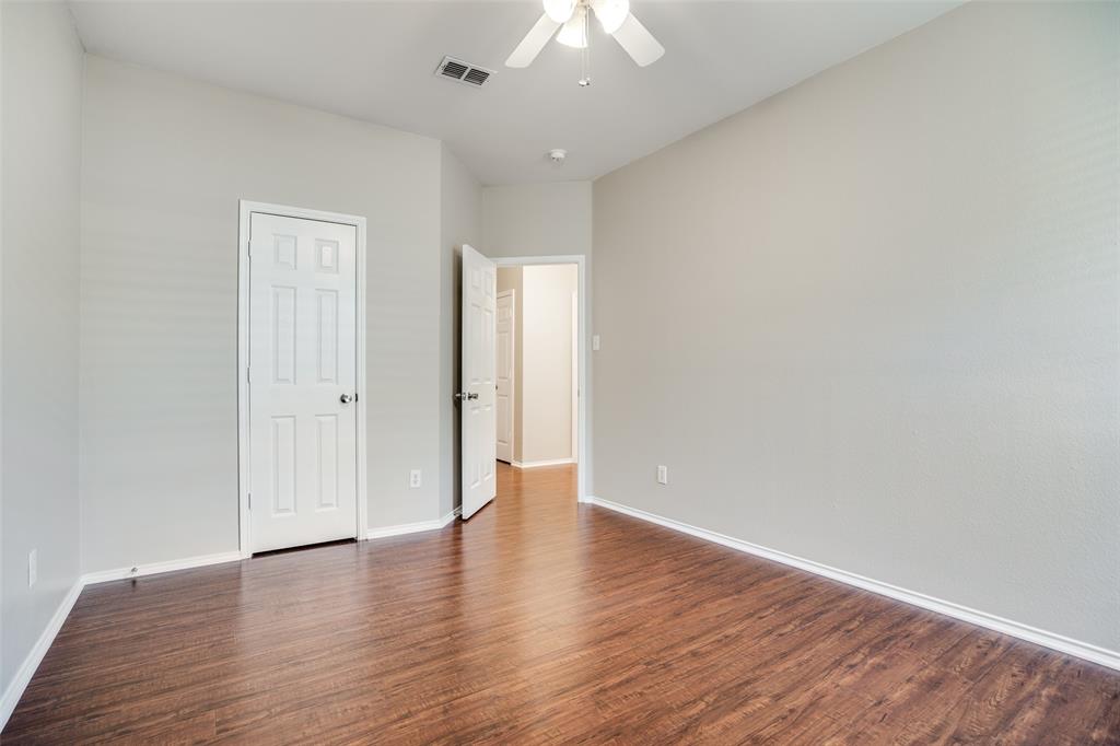 8308 Ram Ridge Road Fort Worth, TX 76137 - Photo 19 of 24 a view of an empty room with wooden floor and a ceiling fan
