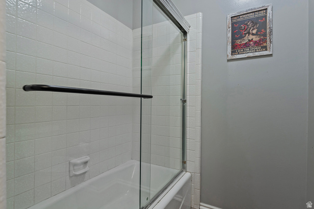3310 Creek Road Salt Lake City, UT 84121 - Photo 27 of 49 Bathtub with white tile surround and clear glass sliding shower doors