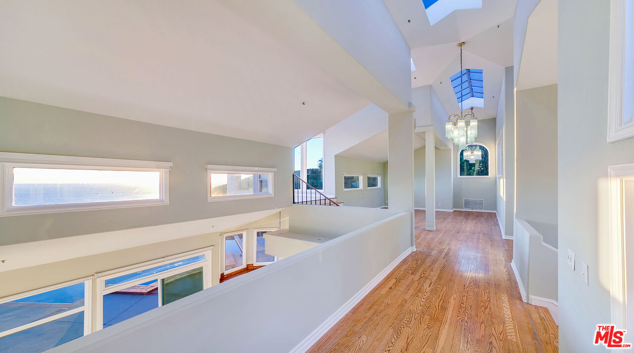 4237 Avenida De La Encinal Malibu, CA 90265 - Photo 18 of 24 a hallway with wooden floor and chandelier
