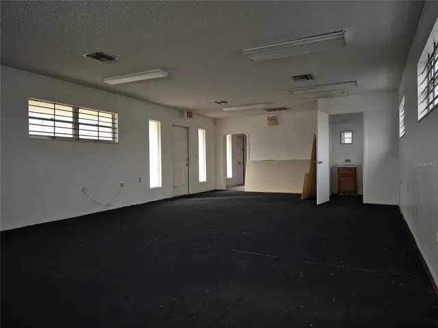 an empty room with windows and closet