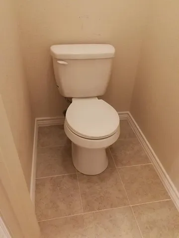 a toilet sitting in a bathroom next to a white wall