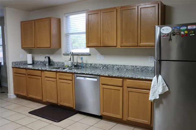 a kitchen with stainless steel appliances granite countertop a refrigerator sink and cabinets
