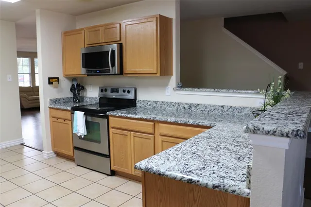 a kitchen with stainless steel appliances granite countertop a sink stove and microwave