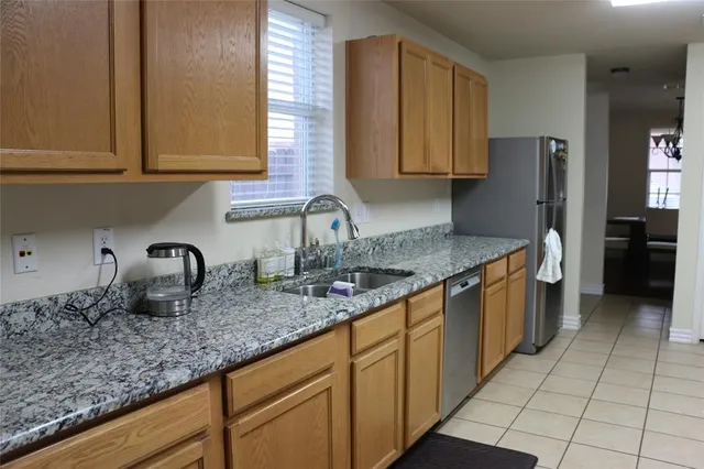 a kitchen with granite countertop a sink a stove and cabinets