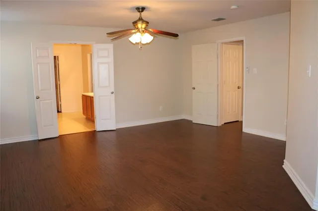 an empty room with wooden floor and window