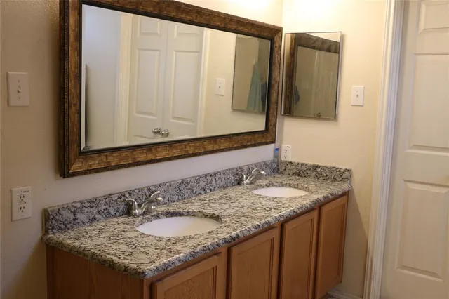 a bathroom with a granite countertop sink and a mirror