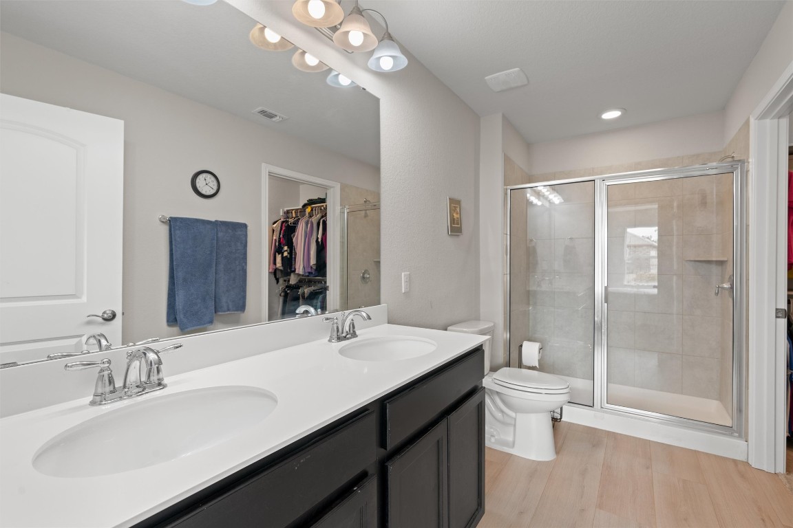 512 Rockport Street Georgetown, TX 78633 - Photo 16 of 26 a bathroom with a double vanity sink toilet and shower