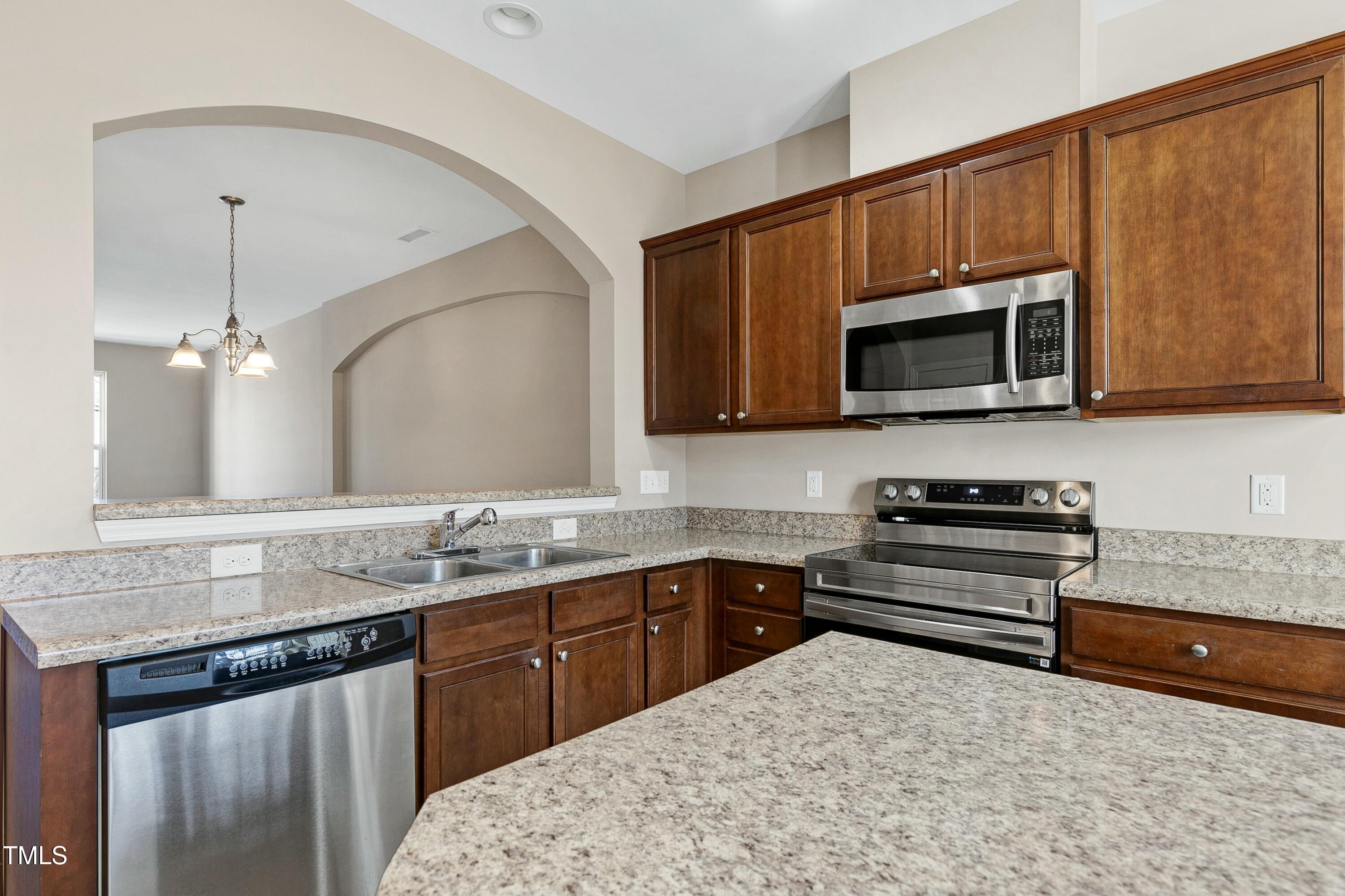 2972 Berkeley Springs Place Raleigh, NC 27616 - Photo 4 of 21 a kitchen with stainless steel appliances granite countertop a sink stove and microwave