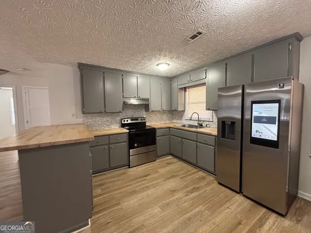 a kitchen with granite countertop stainless steel appliances and refrigerator
