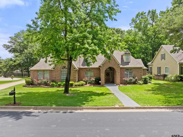 a front view of a house with a garden and trees