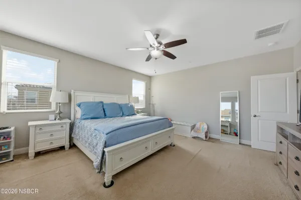 a spacious bedroom with a bed and a chandelier