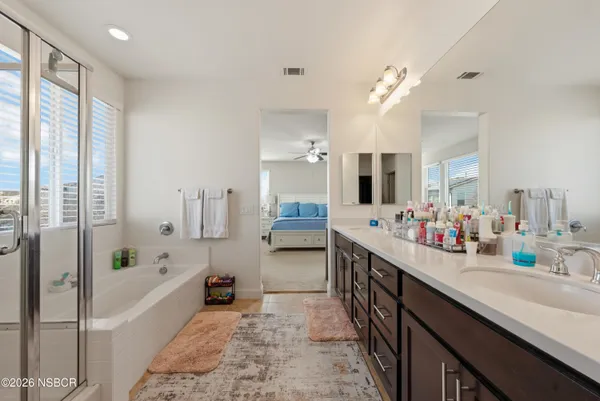 a bathroom with a tub sink and mirror