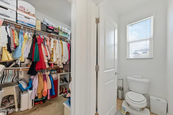 a view of a walk in closet with clothes and shoes